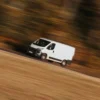 a white van driving on a road